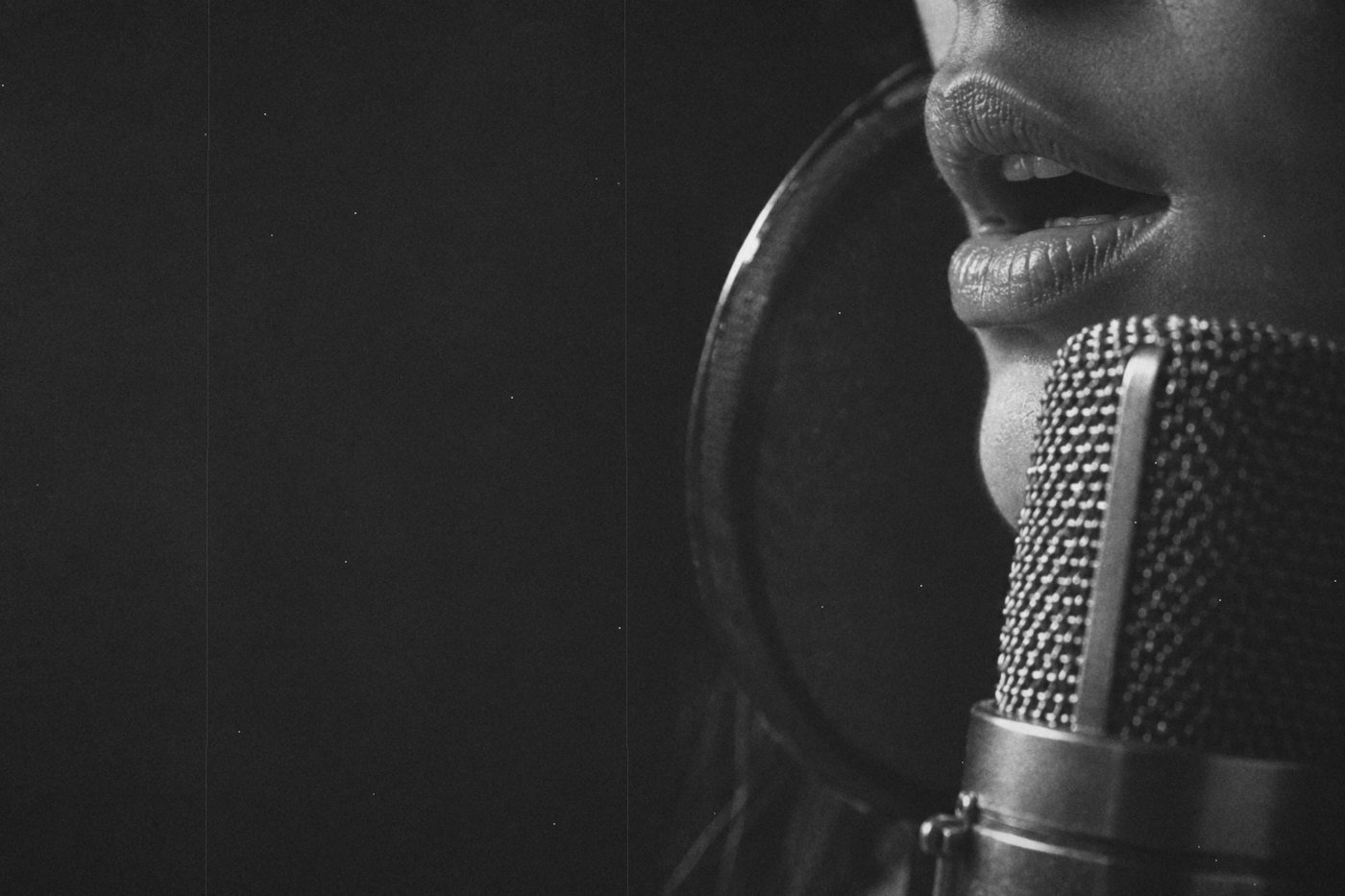 Primer plano de unos labios frente a un micrófono de condensador